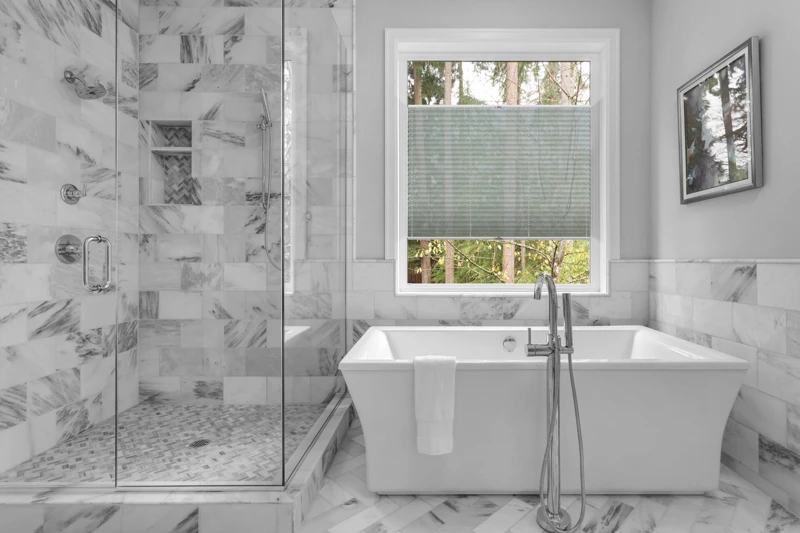 Bathroom with bathtub and shower in new luxury home with all gla