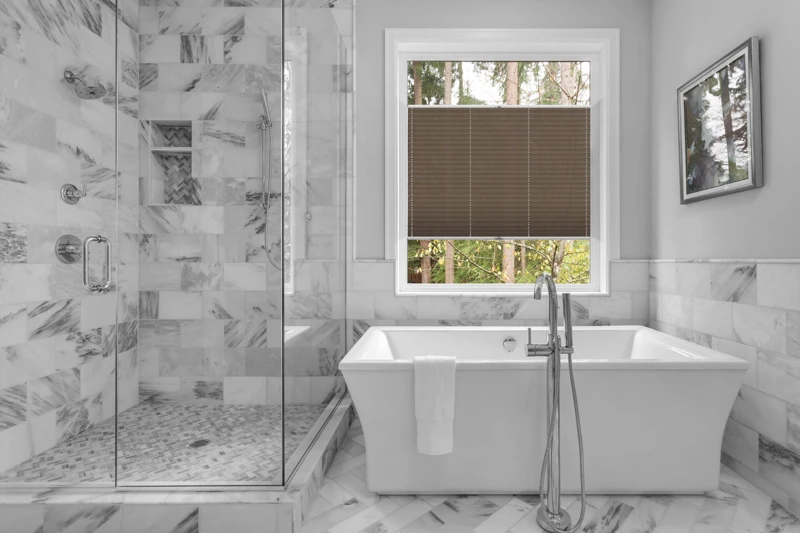 Bathroom with bathtub and shower in new luxury home with all gla