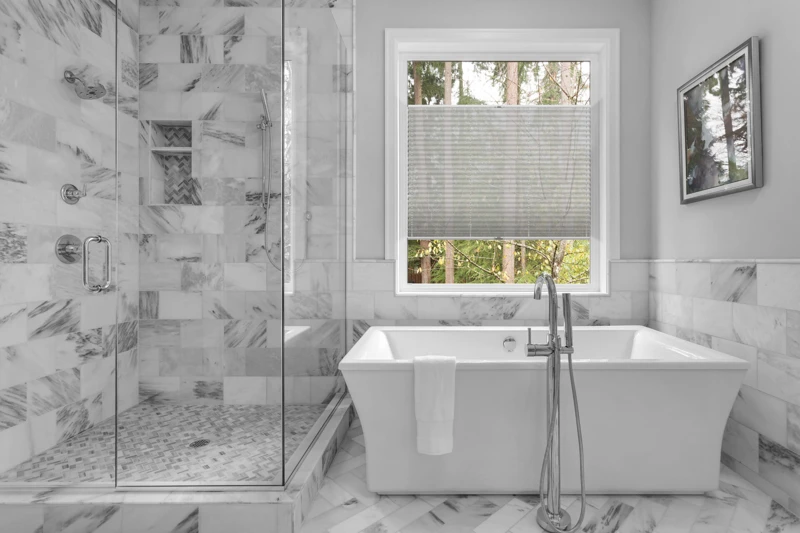 Bathroom with bathtub and shower in new luxury home with all gla