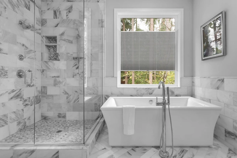 Bathroom with bathtub and shower in new luxury home with all gla