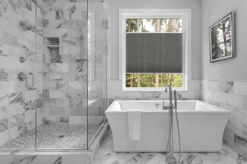 Bathroom with bathtub and shower in new luxury home with all gla