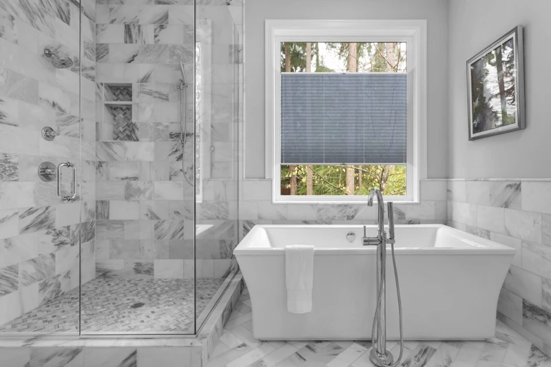 Bathroom with bathtub and shower in new luxury home with all gla