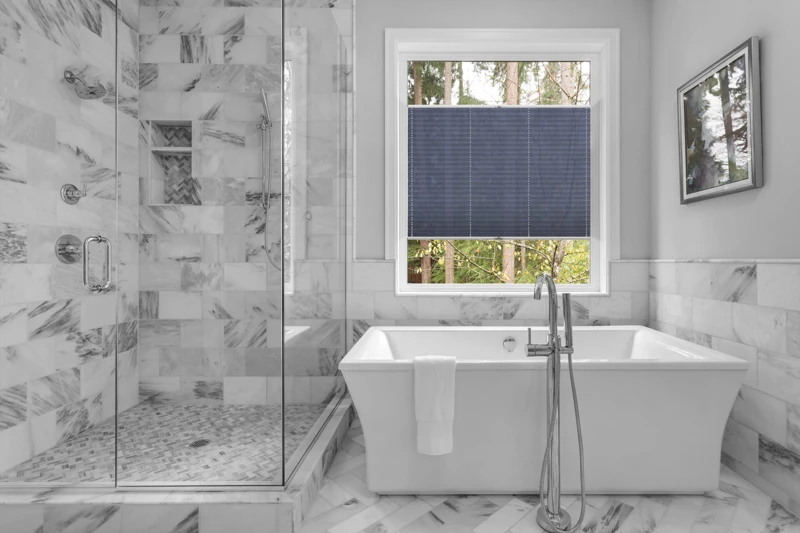 Bathroom with bathtub and shower in new luxury home with all gla