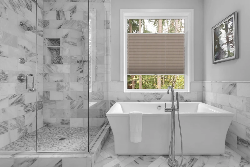 Bathroom with bathtub and shower in new luxury home with all gla