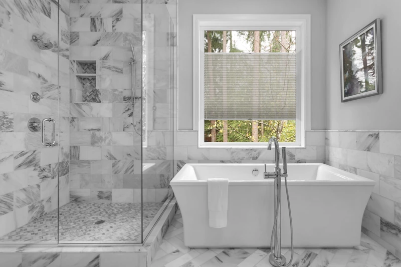 Bathroom with bathtub and shower in new luxury home with all gla