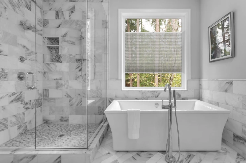 Bathroom with bathtub and shower in new luxury home with all gla