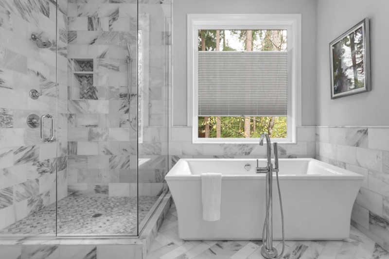 Bathroom with bathtub and shower in new luxury home with all gla