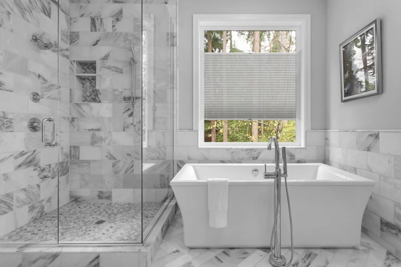 Bathroom with bathtub and shower in new luxury home with all gla