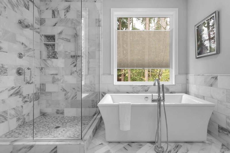 Bathroom with bathtub and shower in new luxury home with all gla