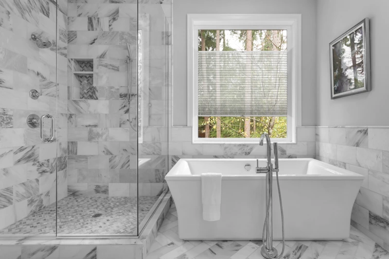 Bathroom with bathtub and shower in new luxury home with all gla