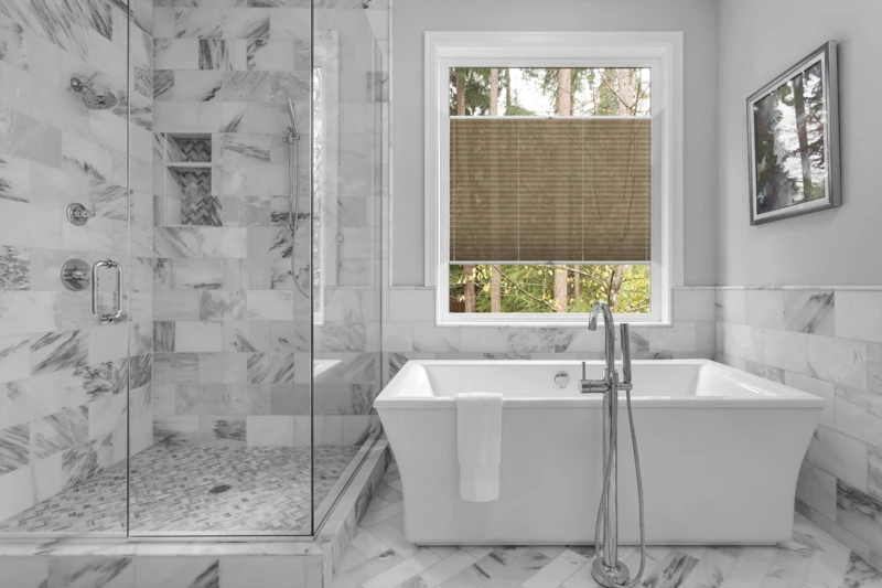 Bathroom with bathtub and shower in new luxury home with all gla