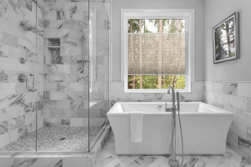 Bathroom with bathtub and shower in new luxury home with all gla