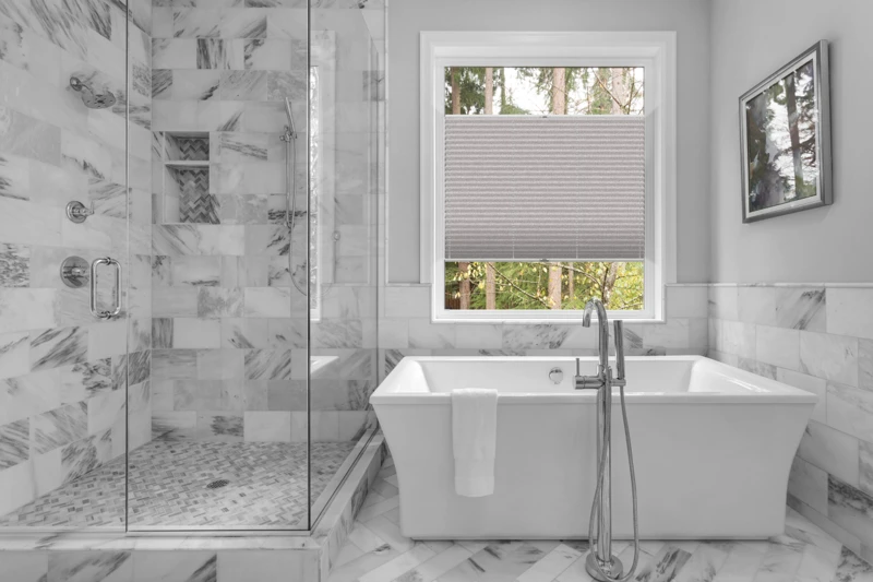 Bathroom with bathtub and shower in new luxury home with all gla